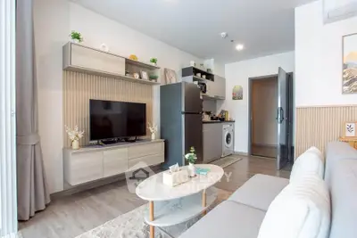 Modern living room with sleek furniture and integrated kitchen appliances