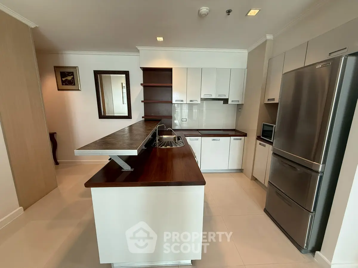 Modern kitchen with sleek cabinetry and stainless steel appliances in a spacious open layout.