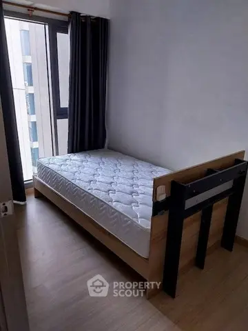 Cozy bedroom with single bed and large window offering natural light.