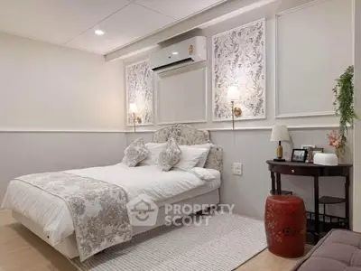 Charming bedroom with elegant decor and cozy ambiance, featuring stylish lighting and air conditioning.