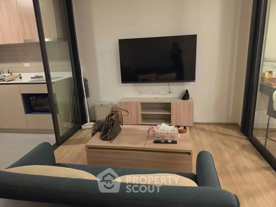 Modern living room with sleek TV setup and cozy seating area in stylish apartment.