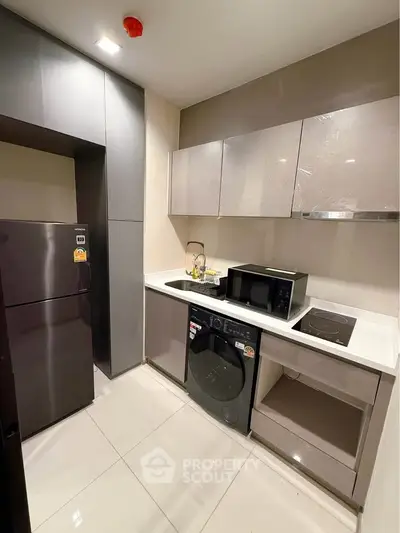 Modern kitchen with sleek cabinets, built-in appliances, and glossy tile flooring in a compact layout.