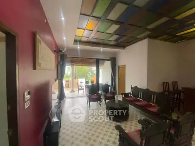 Charming living room with colorful ceiling and open layout to balcony