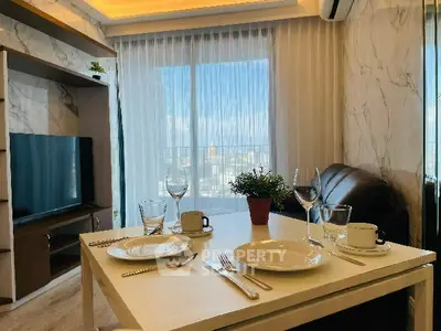 Modern living room with dining table and city view, featuring elegant decor and natural light.