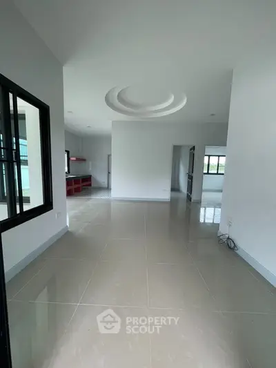 Spacious modern interior with glossy tiled floors and contemporary ceiling design.