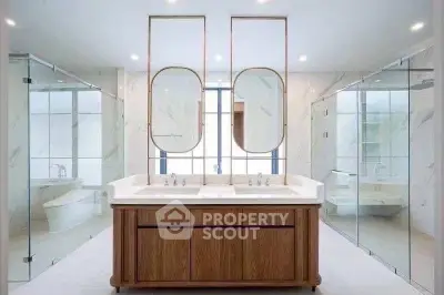 Luxurious modern bathroom with dual sinks and elegant glass shower enclosures.