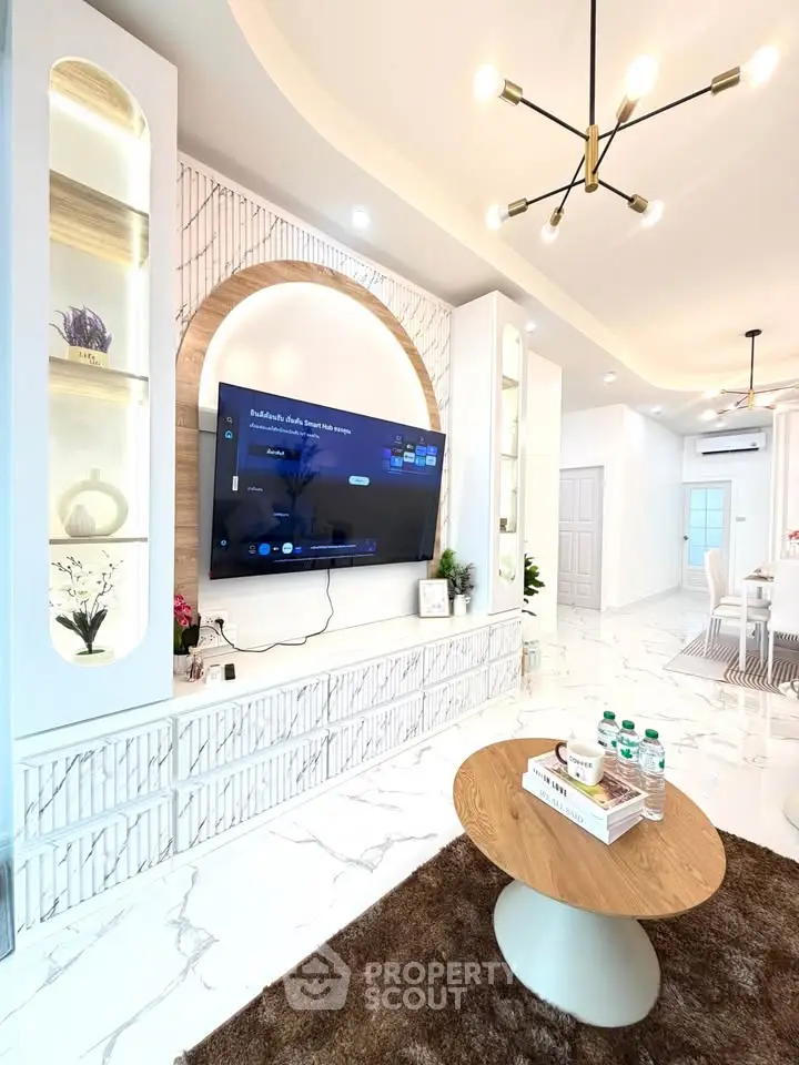 Luxurious modern living room with elegant decor and large TV, featuring marble flooring and stylish lighting.