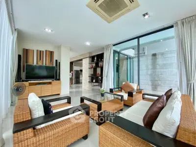 Spacious modern living room with wicker furniture and large glass doors