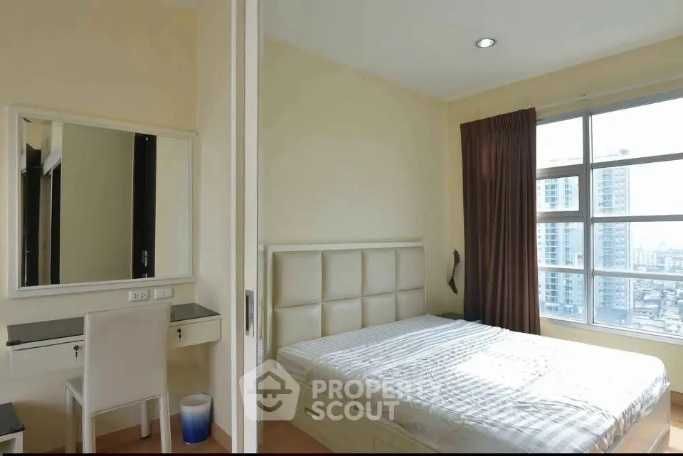 Bright bedroom with large window and city view, featuring a stylish bed and modern decor.