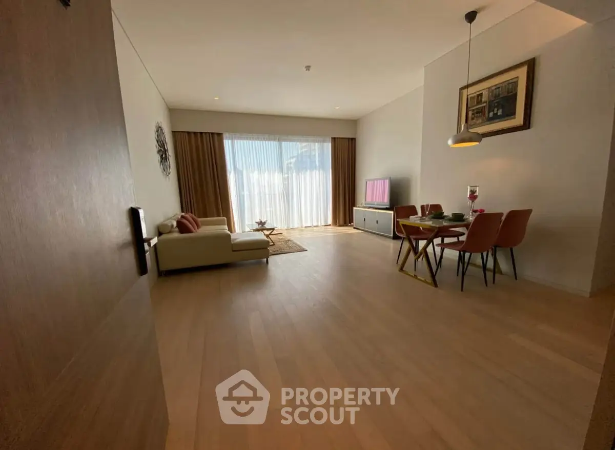 Spacious modern living room with elegant dining area and natural light.