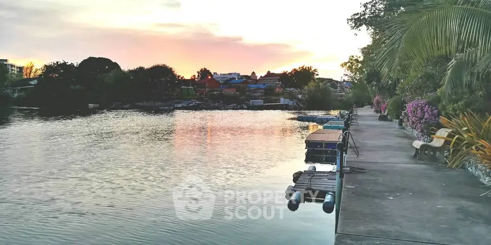 Scenic riverside view with lush greenery and sunset reflections, perfect for tranquil living.