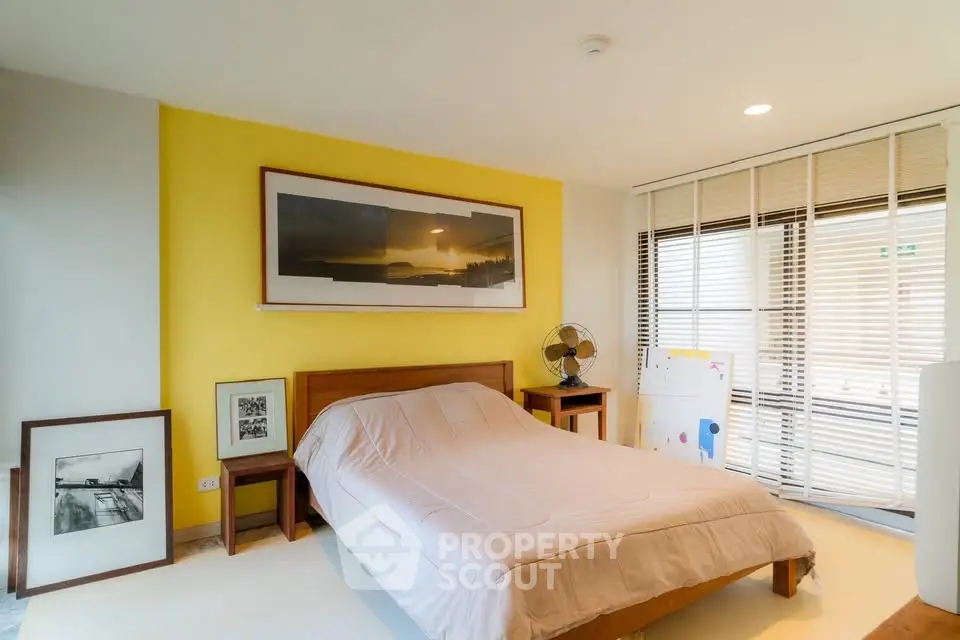 Modern bedroom with yellow accent wall and stylish decor