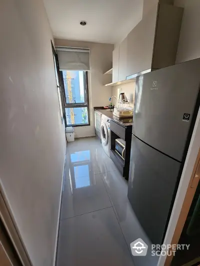 Compact kitchen with modern appliances and natural light