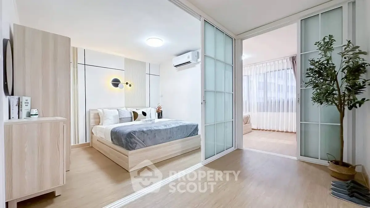 Modern bedroom with sliding doors and stylish decor in a cozy apartment.