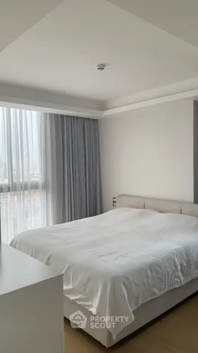 Spacious modern bedroom with large window and elegant decor