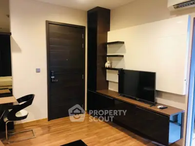 Modern living room with sleek furniture and wall-mounted TV in stylish apartment.