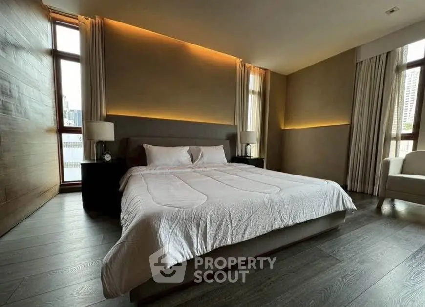 Luxurious bedroom with modern design and large windows offering city views.
