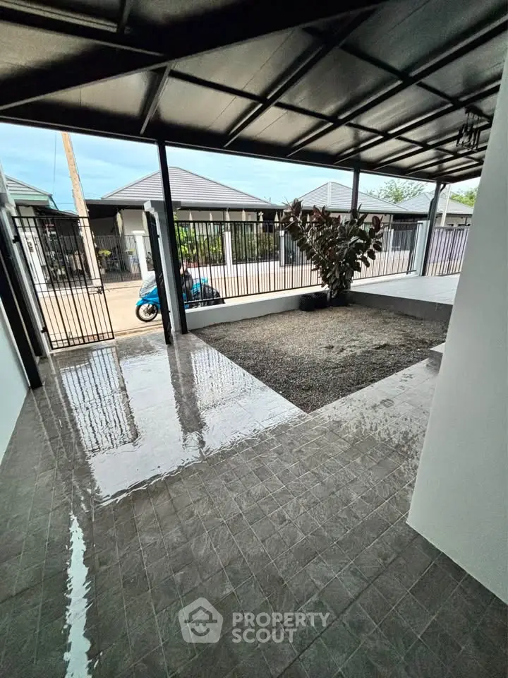 Modern covered patio with sleek tiles and garden view, perfect for outdoor relaxation.