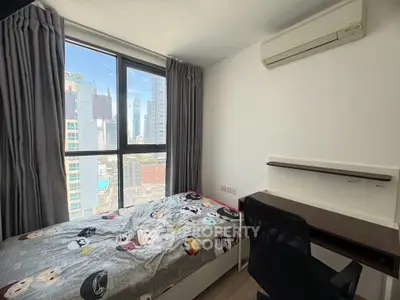 Modern bedroom with city view, featuring a cozy bed and study desk, perfect for urban living.