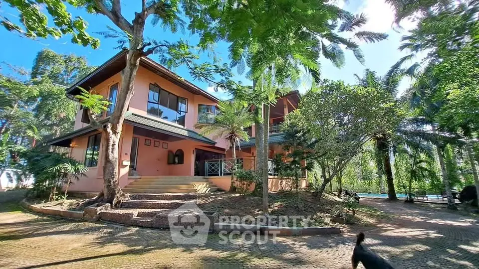 Charming two-story home surrounded by lush greenery and mature trees, offering serene outdoor living.