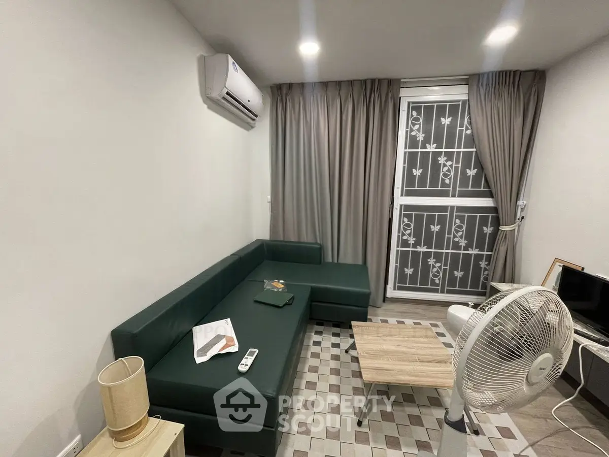 Cozy living room with modern furniture and air conditioning, perfect for relaxation.