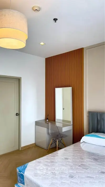 Modern bedroom with stylish wooden paneling and sleek furniture design.