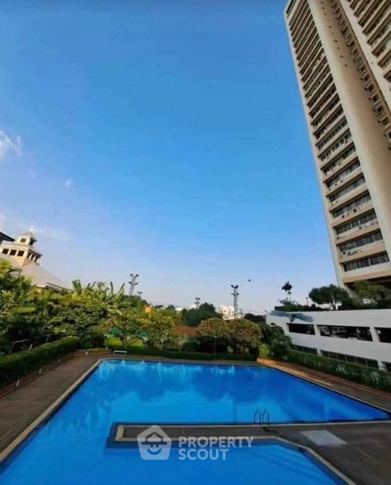 Luxurious high-rise building with stunning pool and lush garden view.