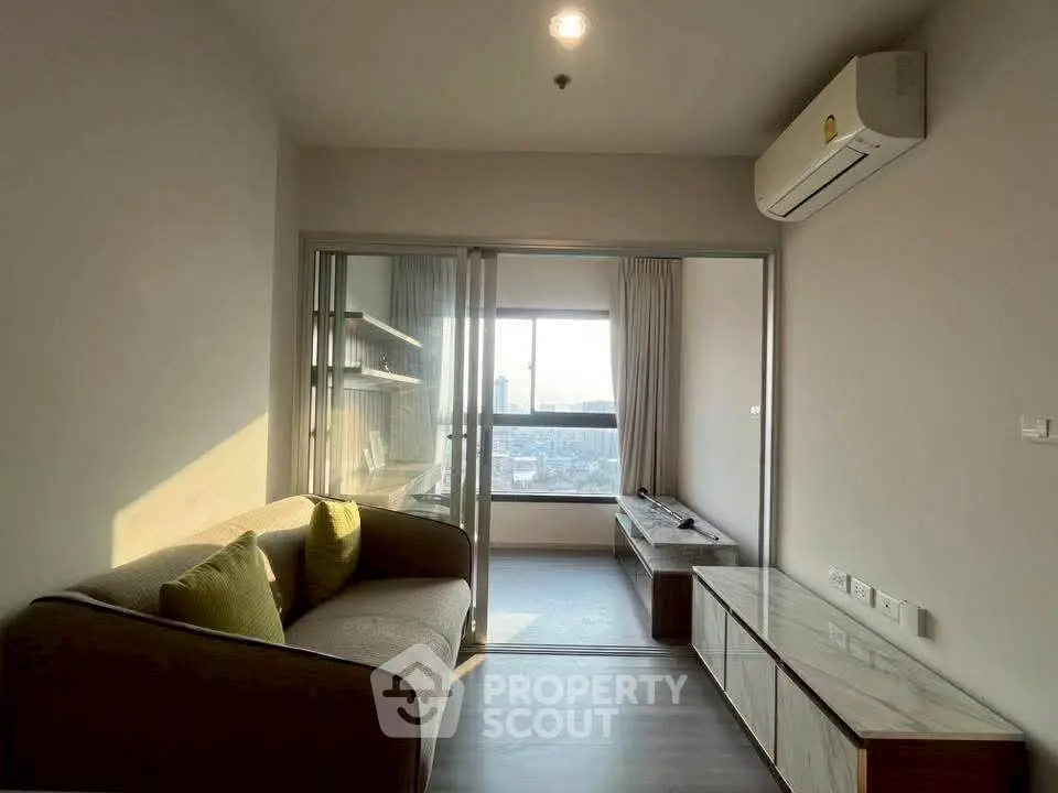 Modern living room with large window and cozy sofa in a stylish apartment.