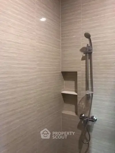 Modern bathroom shower with sleek tile design and built-in shelf