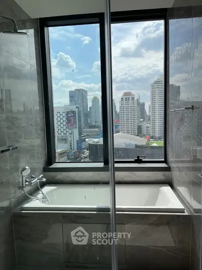 Luxurious bathroom with city view from large window and modern bathtub.