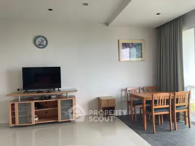 Modern living room with TV, dining table, and elegant decor in a bright apartment.