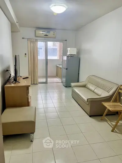 Cozy living room with modern furniture and access to a small balcony, perfect for urban living.