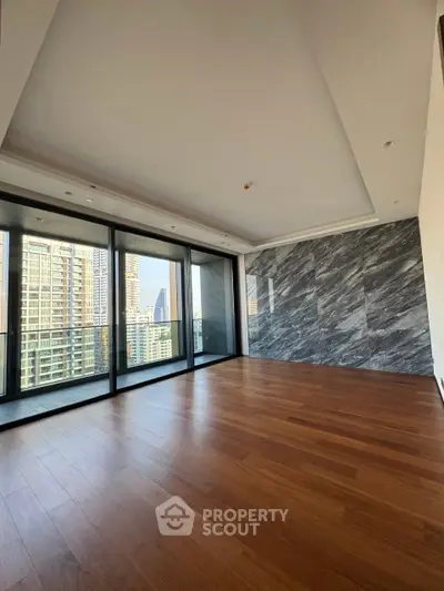 Luxurious modern living room with stunning city view and elegant wooden flooring.