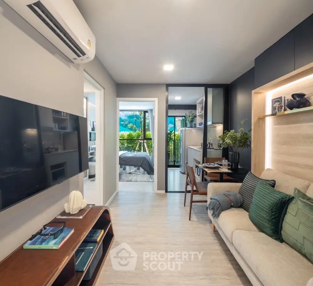 Modern living room with open layout and stylish decor, featuring a view of the bedroom and kitchen.