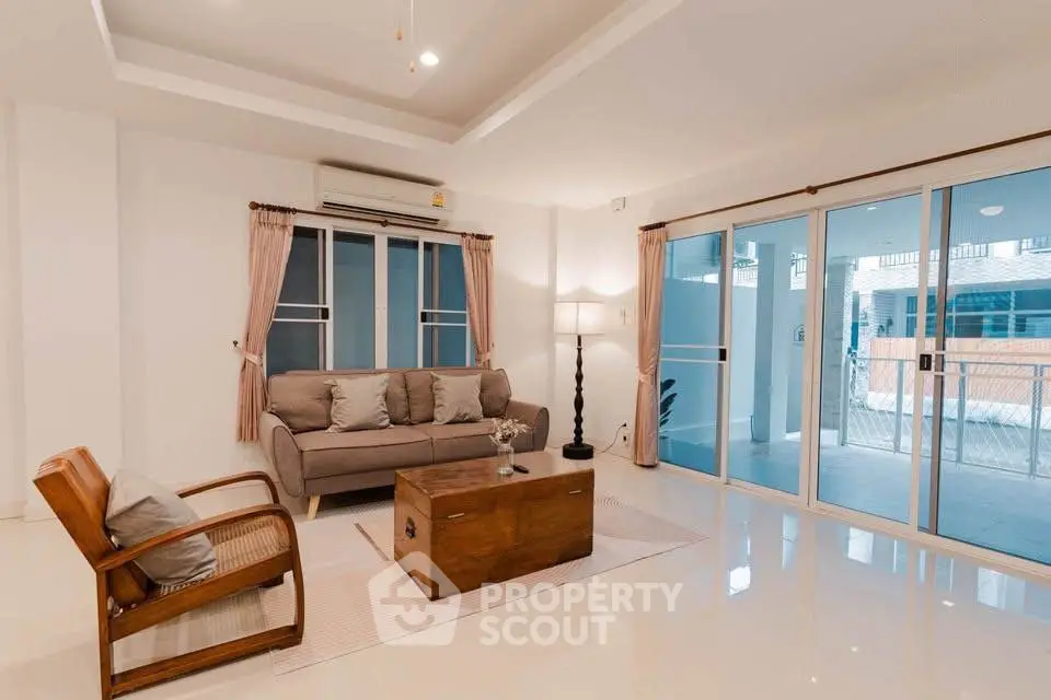 Spacious living room with modern decor and large sliding glass doors leading to a balcony.