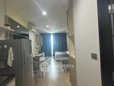 Modern studio apartment with open layout, featuring a sleek kitchen and cozy living area.