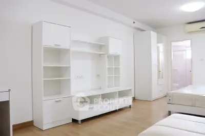 Modern minimalist bedroom with sleek white furniture and wooden flooring