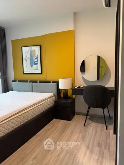 Modern bedroom with stylish decor, featuring a comfortable bed, chic vanity, and vibrant accent wall.