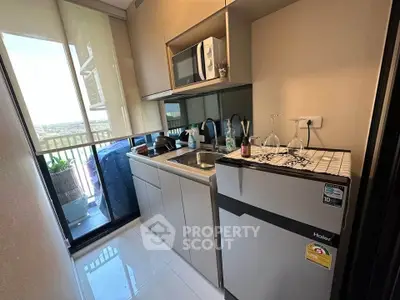 Modern compact kitchen with balcony view, featuring sleek cabinetry and appliances, ideal for urban living.