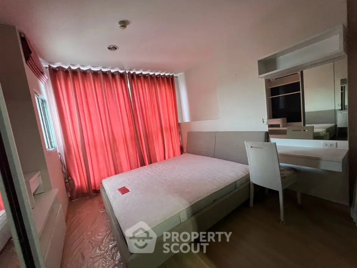 Cozy bedroom with red curtains and modern furnishings in a stylish apartment.