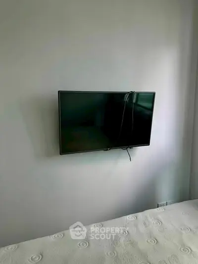 Minimalist bedroom with wall-mounted TV and simple decor