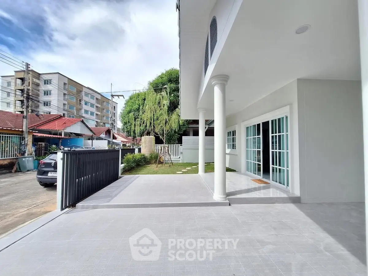 Spacious modern building exterior with elegant columns and large patio.