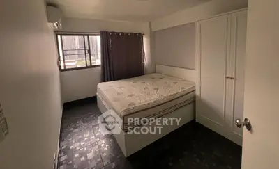 Cozy bedroom with large window and ample storage in modern apartment