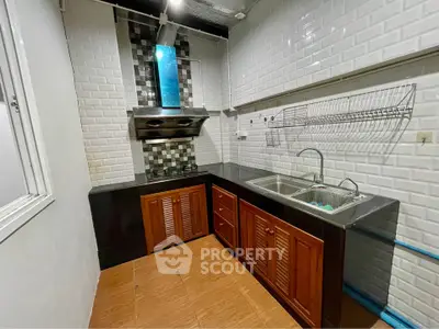 Charming kitchen with modern backsplash and wooden cabinets, perfect for culinary enthusiasts.