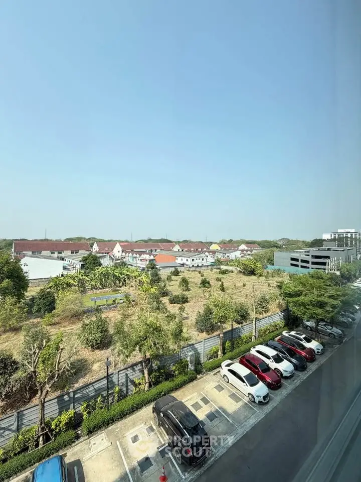 Scenic view from high-rise overlooking residential area and parking lot, ideal for urban living.