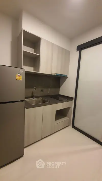 Modern compact kitchen with sleek cabinetry and stainless steel appliances