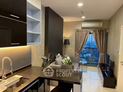 Modern living room with open kitchen and city view, featuring sleek black cabinetry and cozy seating area.
