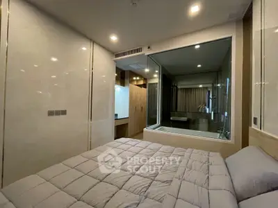 Luxurious bedroom with ensuite glass-walled bathtub and modern decor