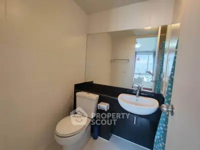 Modern bathroom with sleek fixtures and large mirror in a contemporary apartment.