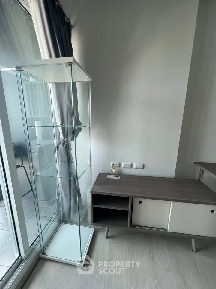 Modern interior with glass display cabinet and sleek storage unit in a bright room.